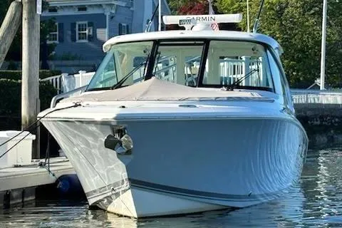 The Image of 2024 Pursuit DC 326 Dual Console boat docked in a marina, front view. - 0