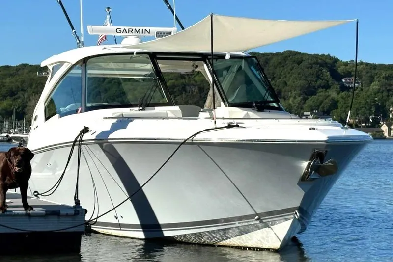 Slide: The Image of 2024 Pursuit DC 326 Dual Console boat docked with canopy, featuring Garmin equipment. - 31