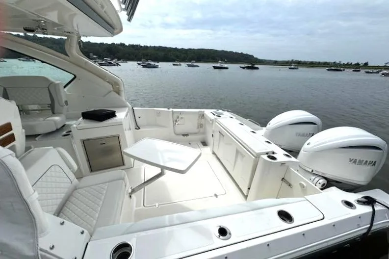 Slide: The Image of 2024 Pursuit DC 326 Dual Console boat with Yamaha engines on a serene lake. - 4