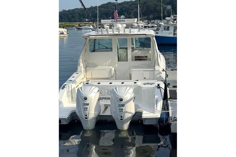 Slide: The Image of 2024 Pursuit DC 326 Dual Console boat with twin 300 V6 engines docked in a marina. - 2