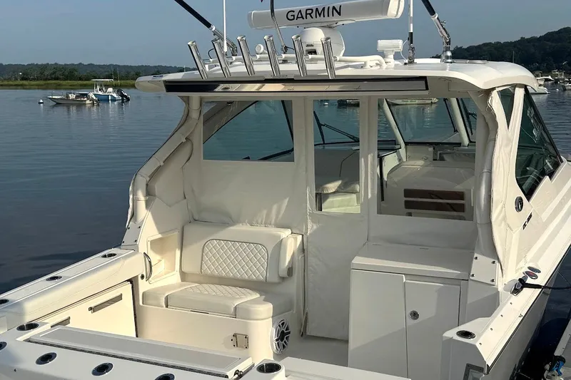 Slide: The Image of 2024 Pursuit DC 326 Dual Console boat with spacious seating, docked on calm water. - 1