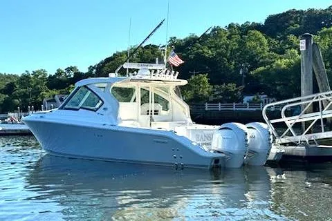Slide: The Image of 2024 Pursuit DC 326 Dual Console boat docked in a serene marina setting. - 29