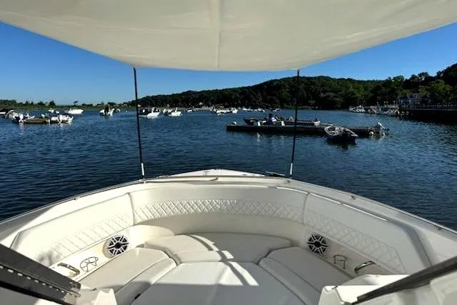 Slide: The Image of 2024 Pursuit DC 326 Dual Console boat on a scenic lake with other boats. - 33