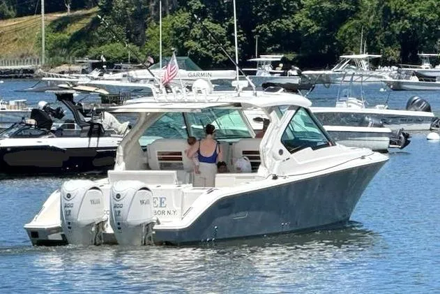 Slide: The Image of 2024 Pursuit DC 326 Dual Console boat cruising on a sunny day in a marina. - 34