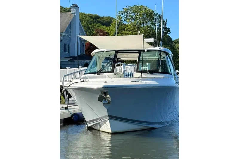 Slide: The Image of 2024 Pursuit DC 326 Dual Console boat docked, featuring sleek design and modern amenities. - 32