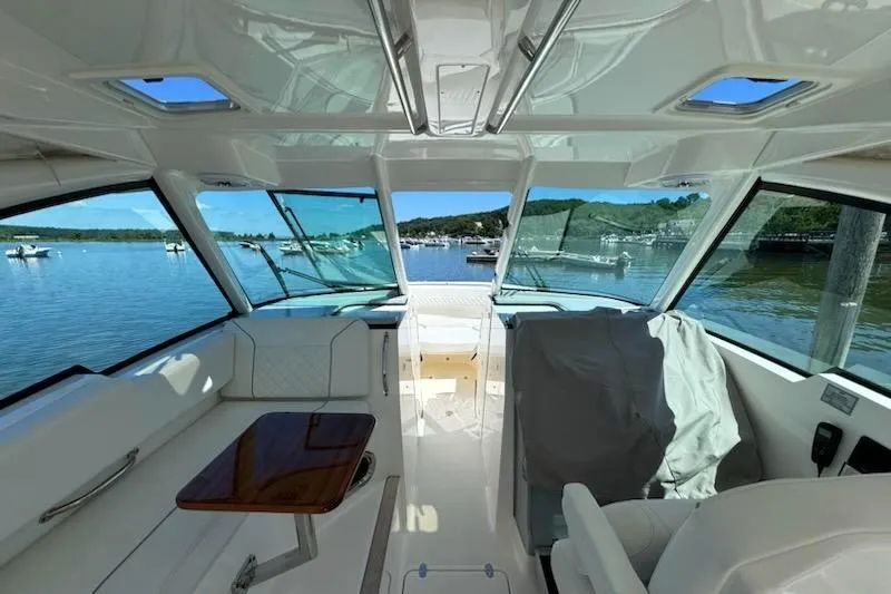 Slide: The Image of 2024 Pursuit DC 326 Dual Console interior with scenic waterfront view. - 5