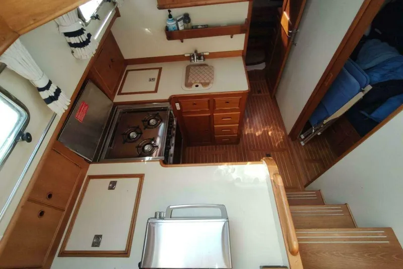 Slide: The Image of Interior of 1996 Grand Banks Eastbay 40 Flybridge, featuring a compact kitchen area. - 54