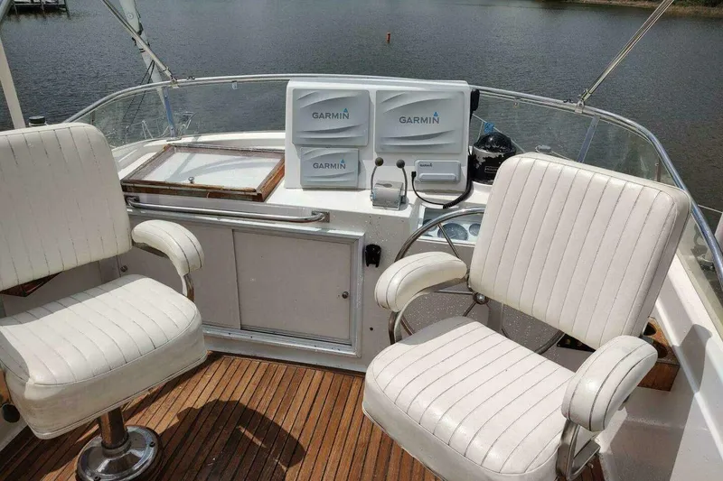 Slide: The Image of Flybridge of 1996 Grand Banks Eastbay 40 with Garmin navigation, featuring two white captain chairs. - 109