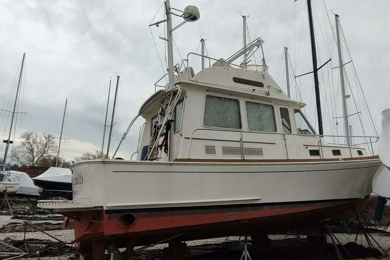 Slide: The Image of 1996 Grand Banks Eastbay 40 Flybridge yacht on dry dock, surrounded by sailboats. - 118