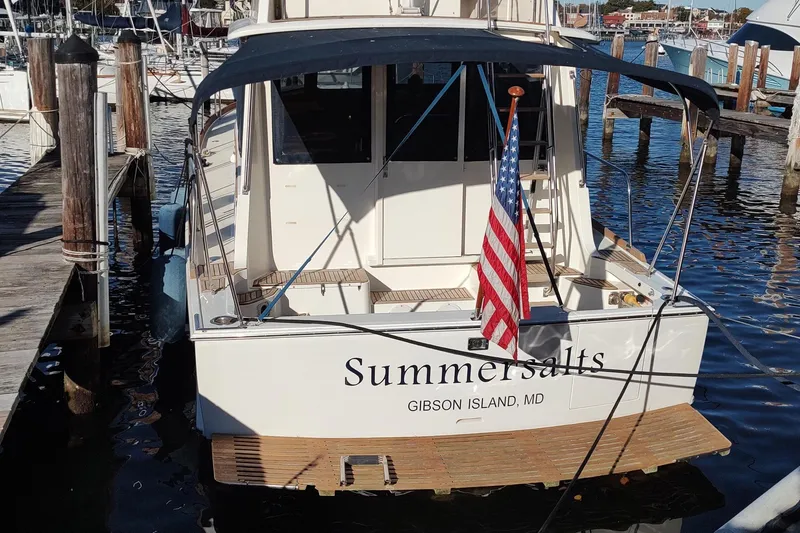 Slide: The Image of 1996 Grand Banks Eastbay 40 Flybridge docked, displaying American flag, named "Summersalts." - 3