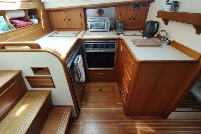 Slide: The Image of 1996 Grand Banks Eastbay 40 Flybridge kitchen with wood cabinetry, stove, and appliances. - 59