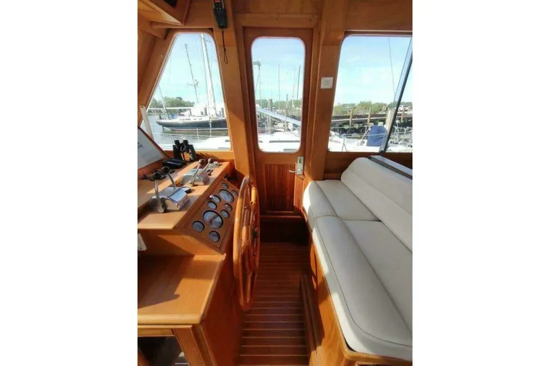 Slide: The Image of 1996 Grand Banks Eastbay 40 Flybridge interior with wooden helm and cushioned seating. - 31