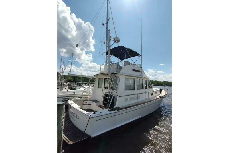 Slide: The Image of 1996 Grand Banks Eastbay 40 Flybridge yacht docked under a sunny sky. - 8