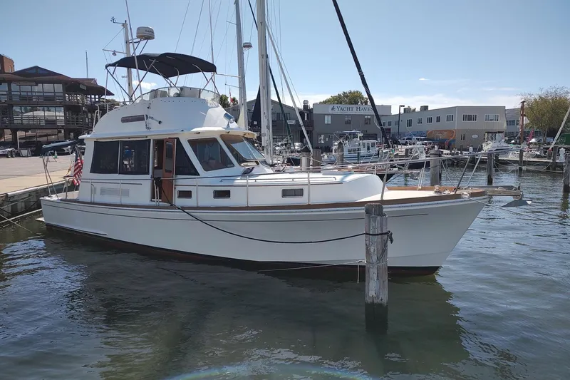 Slide: The Image of 1996 Grand Banks Eastbay 40 Flybridge yacht docked at a marina. - 2