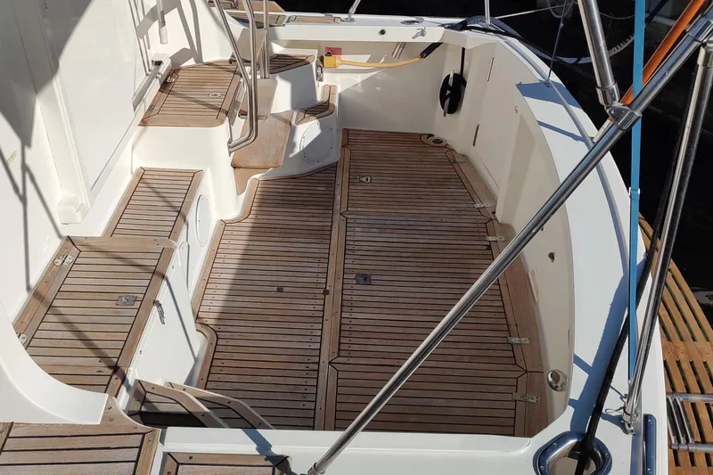Slide: The Image of 1996 Grand Banks Eastbay 40 Flybridge deck with teak flooring and seating area. - 14