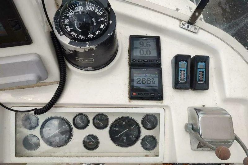 Slide: The Image of Helm controls of a 1996 Grand Banks Eastbay 40 Flybridge with compass and gauges. - 115