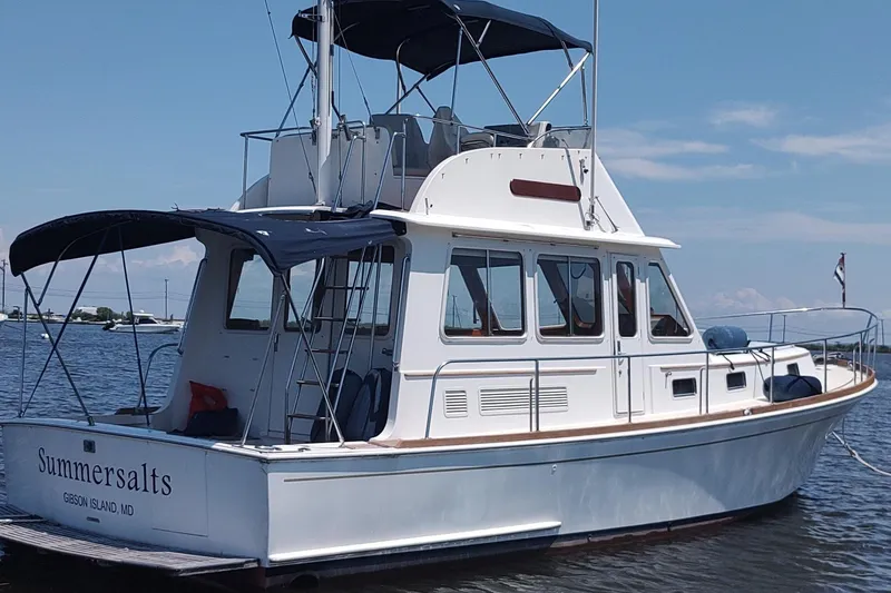 Slide: The Image of 1996 Grand Banks Eastbay 40 Flybridge yacht on water, featuring a sleek design and flybridge. - 5