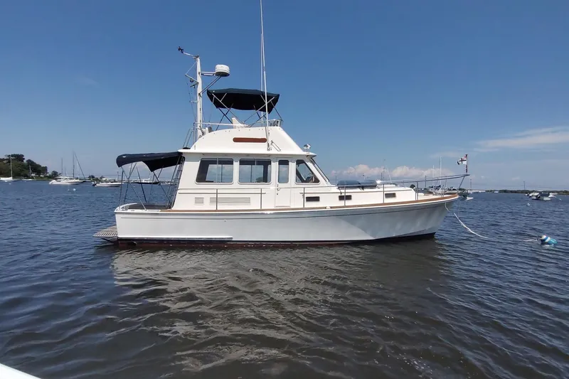 Slide: The Image of 1996 Grand Banks Eastbay 40 Flybridge yacht on calm water under clear sky. - 6