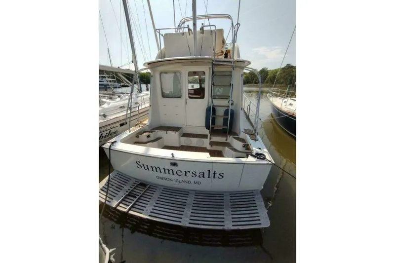 Slide: The Image of 1996 Grand Banks Eastbay 40 Flybridge docked, rear view with "Summersalts" name visible. - 11
