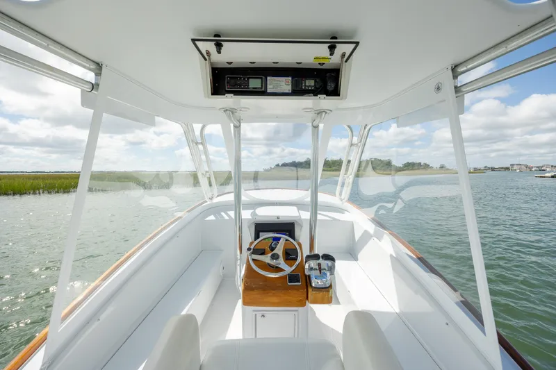 Slide: The Image of Custom Carolina 26 Tideline Boatworks Express 2005, helm view, open water, clear skies. - 11