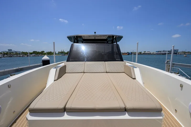Slide: The Image of 2023 De Antonio Yachts D42 Open with luxurious sunbed, docked by the waterfront. - 4