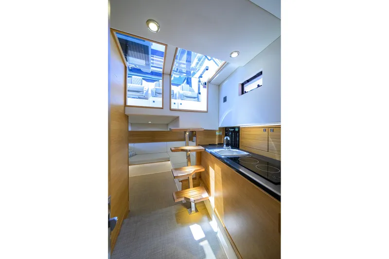 Slide: The Image of Interior of 2023 De Antonio Yachts D42 Open, featuring modern kitchen and wooden stairs. - 28