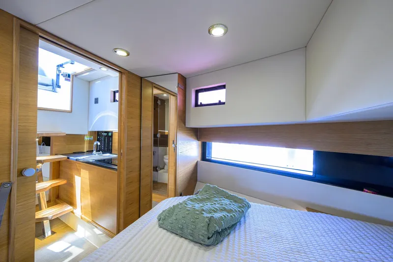 Slide: The Image of Luxurious interior of 2023 De Antonio Yachts D42 Open, featuring modern wood finishes and cozy bedding. - 25