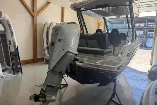 Slide: The Image of 2026 Monterey Elite 25 OB boat with powerful outboard motor in a showroom. - 3