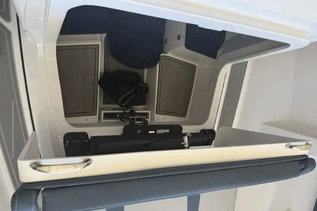 Slide: The Image of Interior view of 2026 Monterey Elite 25 OB boat cabin with seating and storage. - 12