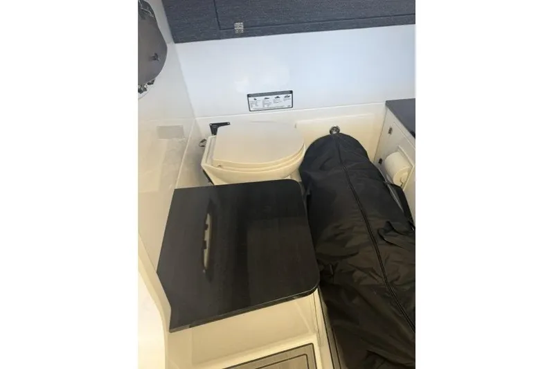 Slide: The Image of Interior of 2026 Monterey Elite 25 OB boat featuring a compact bathroom setup. - 14