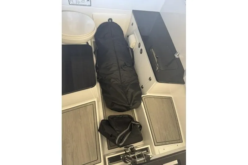 Slide: The Image of Interior of 2026 Monterey Elite 25 OB boat with storage compartments and seating. - 15