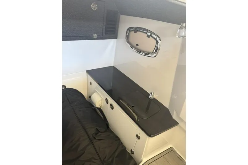Slide: The Image of Interior of 2026 Monterey Elite 25 OB boat with sleek countertop and compact sink. - 13