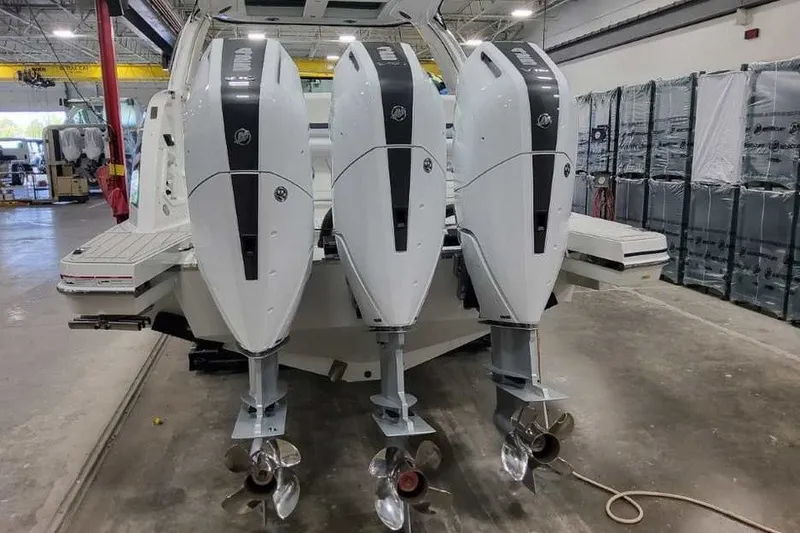 Slide: The Image of 2027 Formula 360 Crossover Bowrider OB with triple outboard engines in a workshop. - 12