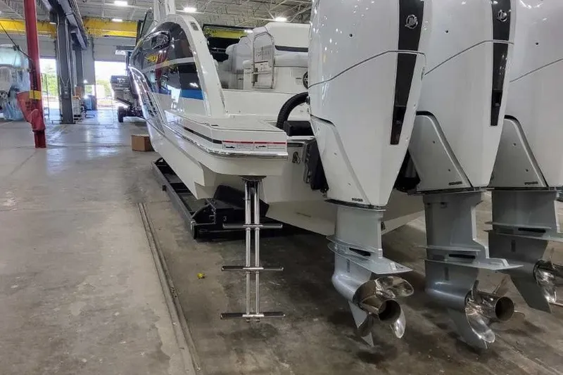 Slide: The Image of 2027 Formula 360 Crossover Bowrider OB with triple outboard engines in a warehouse setting. - 11