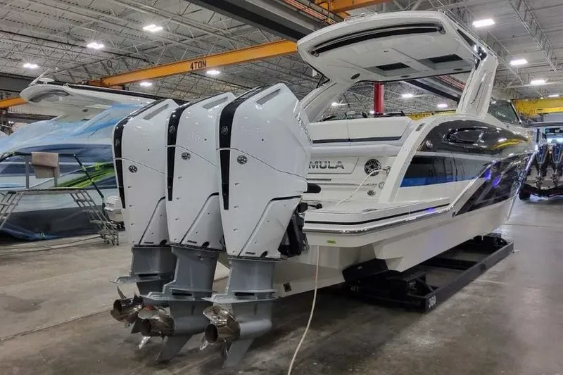 Slide: The Image of 2027 Formula 360 Crossover Bowrider OB with triple outboard engines in a showroom. - 5