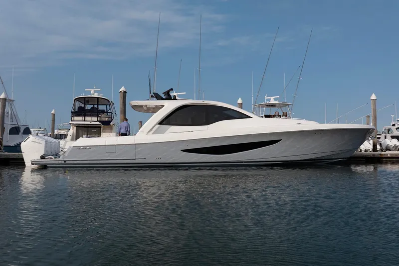Slide: The Image of 2026 Valhalla Boatworks V-55 Sport Yacht docked in marina, sleek design, clear sky. - 1