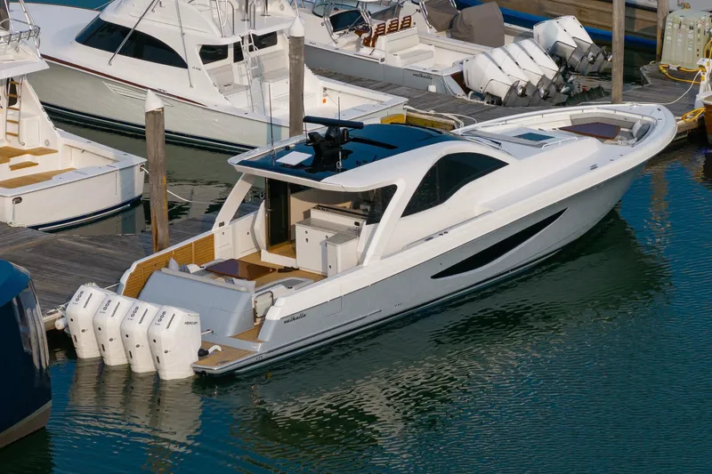 Slide: The Image of 2026 Valhalla Boatworks V-55 Sport Yacht docked, showcasing sleek design and powerful engines. - 4