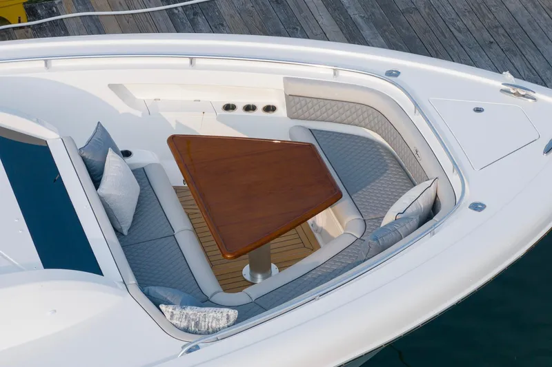 Slide: The Image of 2026 Valhalla V-55 Sport Yacht bow seating with elegant wooden table and cushions. - 11