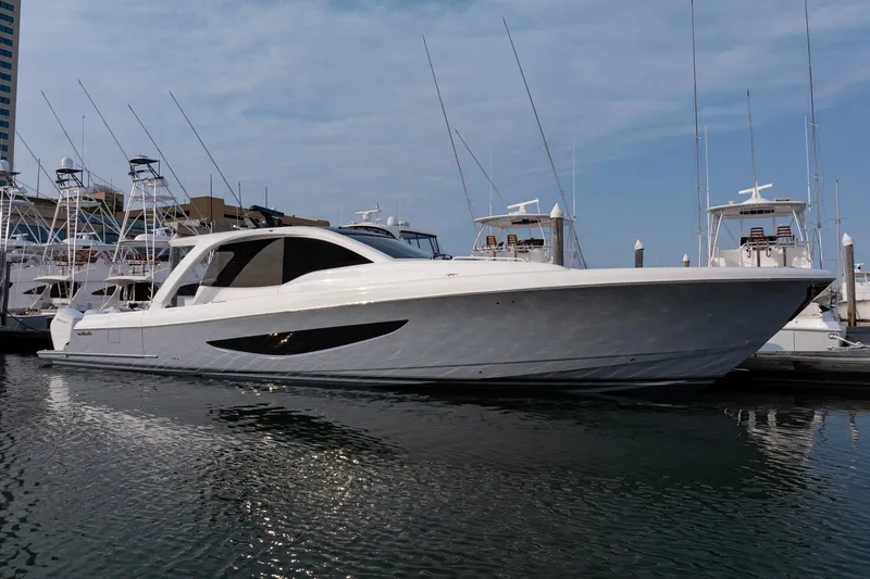 Slide: The Image of 2026 Valhalla Boatworks V-55 Sport Yacht docked in marina, sleek design, clear sky. - 2