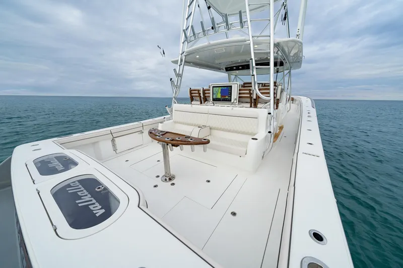 Slide: The Image of 2026 Valhalla Boatworks V-55 on open water, showcasing spacious deck and seating. - 13