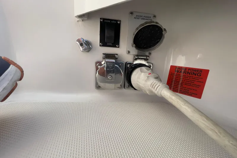 Slide: The Image of 2007 Luhrs 31 Open boat shore power connection with warning label and breaker switch. - 21