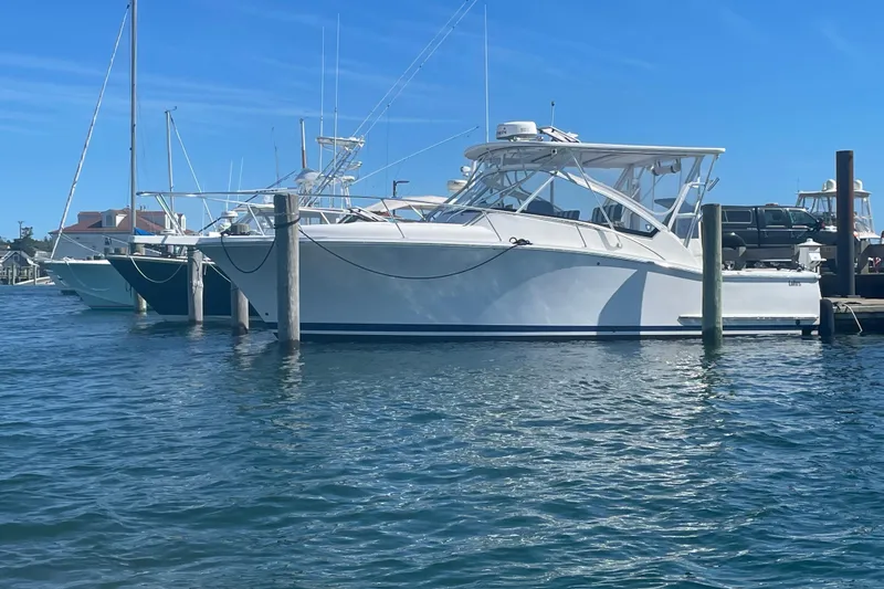 The Image of 2007 Luhrs 31 Open boat docked in a marina under clear blue skies. - 0