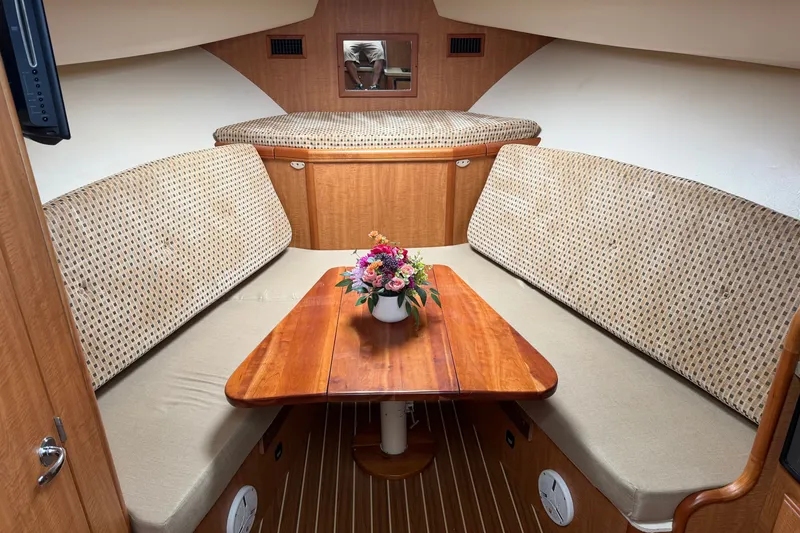 Slide: The Image of Cozy interior of 2007 Luhrs 31 Open boat with wooden table and floral centerpiece. - 15