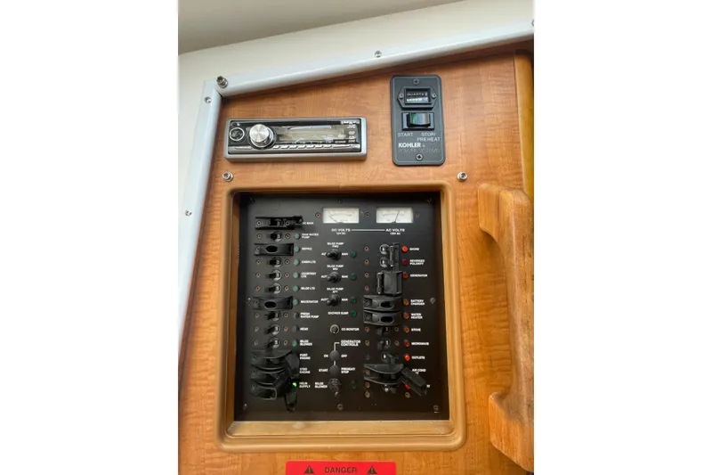 Slide: The Image of Electrical control panel on a 2007 Luhrs 31 Open boat, featuring switches and a stereo system. - 16