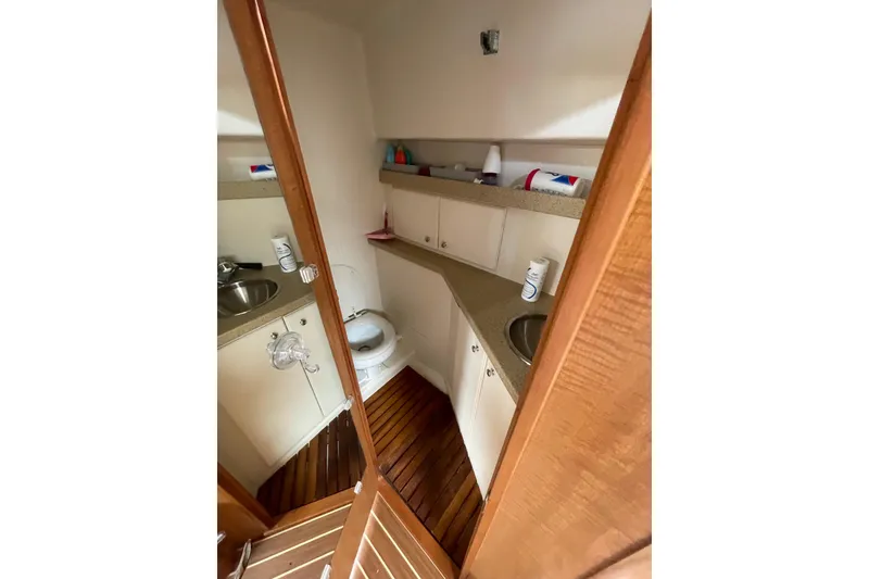 Slide: The Image of 2007 Luhrs 31 Open boat bathroom with wooden flooring and compact amenities. - 14