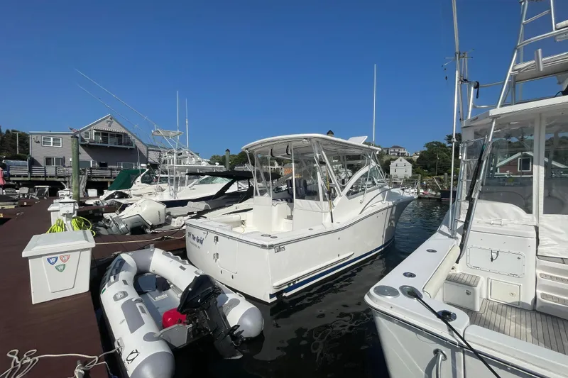 Slide: The Image of 2007 Luhrs 31 Open boat docked at marina, surrounded by other vessels. - 2