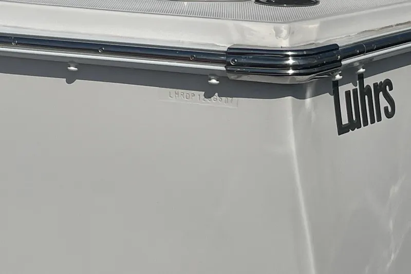 Slide: The Image of 2007 Luhrs 31 Open boat, close-up of hull with logo and chrome detailing. - 25