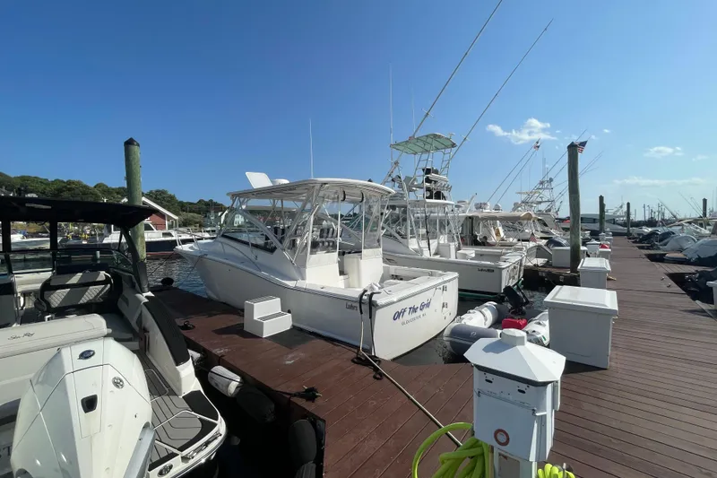 Slide: The Image of 2007 Luhrs 31 Open boat docked at marina under clear blue sky. - 1