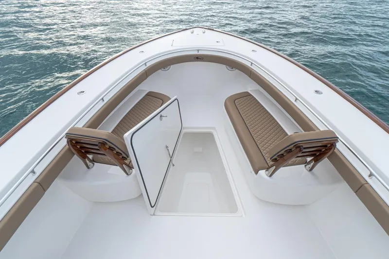 Slide: The Image of 2026 Valhalla Boatworks V-41 interior with open storage and cushioned seating on calm water. - 8