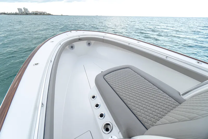 Slide: The Image of 2027 Valhalla Boatworks V-33 bow with cushioned seating, on calm ocean waters. - 10